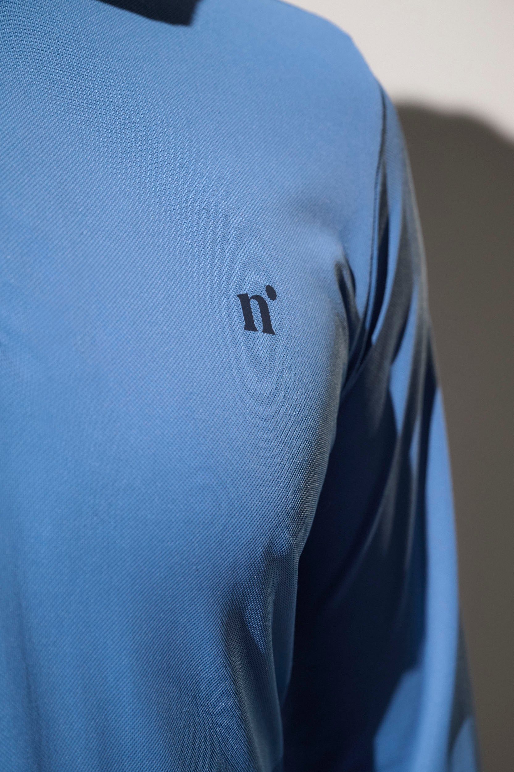 Polo anti-UV bleu léger pour homme, UPF50+, idéal pour le golf ou le tennis sous le soleil.