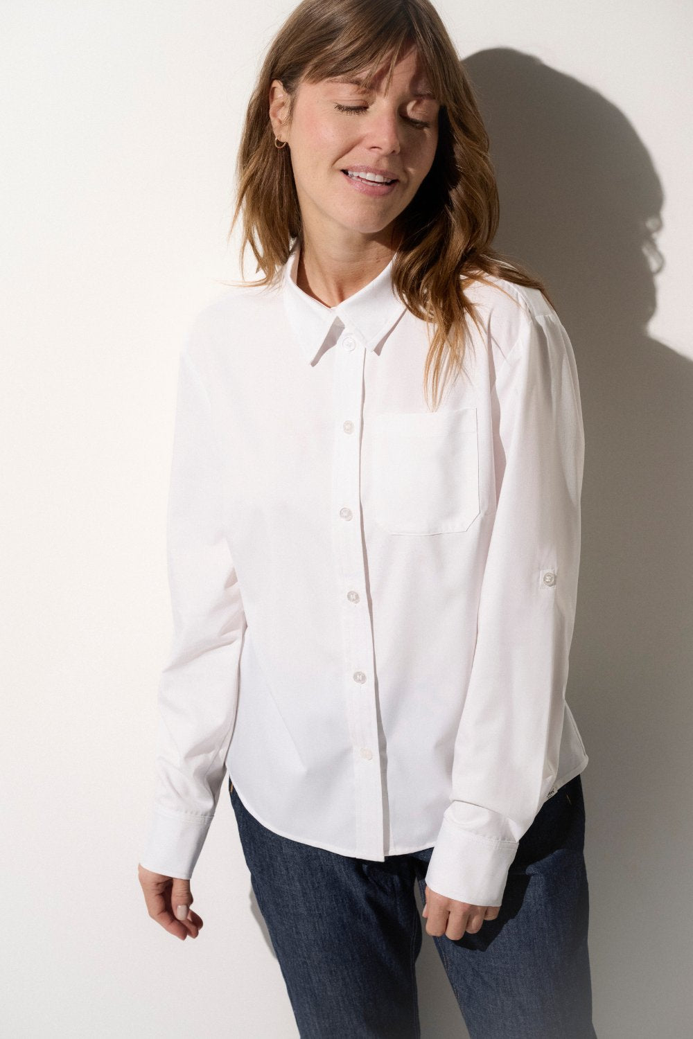 Chemise anti-UV blanche pour femme, légère et élégante, offrant une protection solaire UPF 50+ pour les journées en plein air.