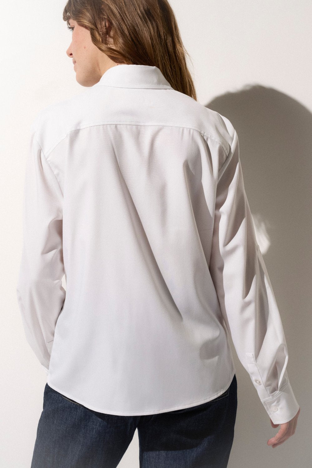 Chemise anti-UV blanche pour femme, offrant une excellente protection contre les rayons nocifs du soleil.