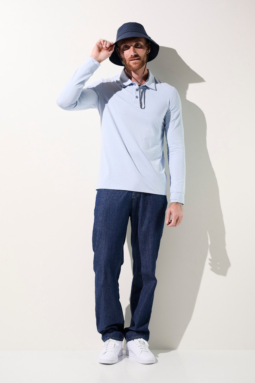 Homme portant un polo anti-UV Saint-Malo bleu clair UPF 50+, idéal pour se protéger du soleil.