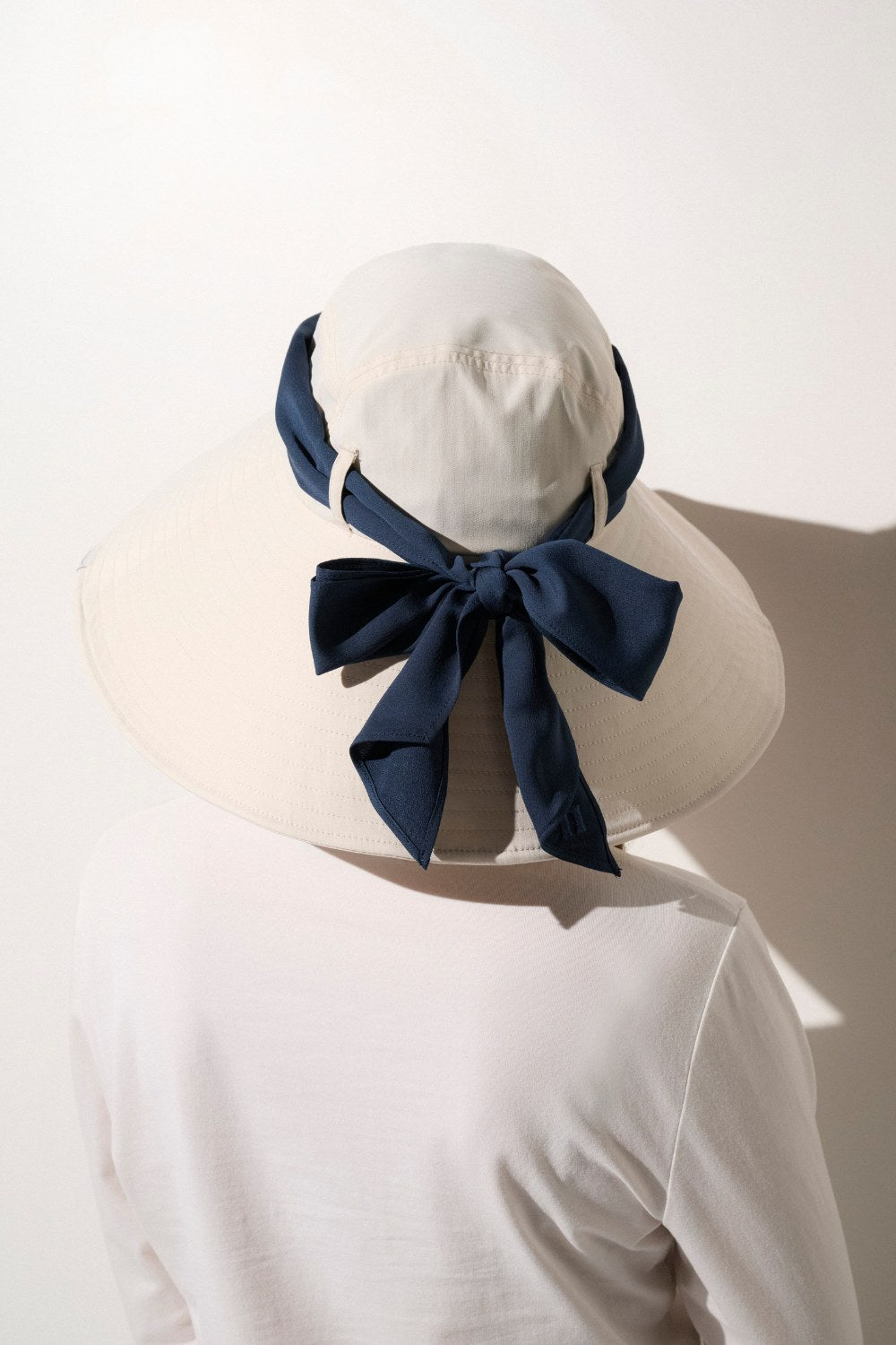 Chapeau anti-UV blanc perlé pour femme, offrant élégance et protection solaire dans toutes les activités du quotidien.