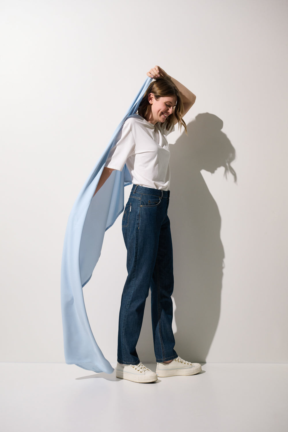 Femme portant une étole anti-UV - Positano bleu léger, protection solaire UPF 50+ avec une tenue décontractée.