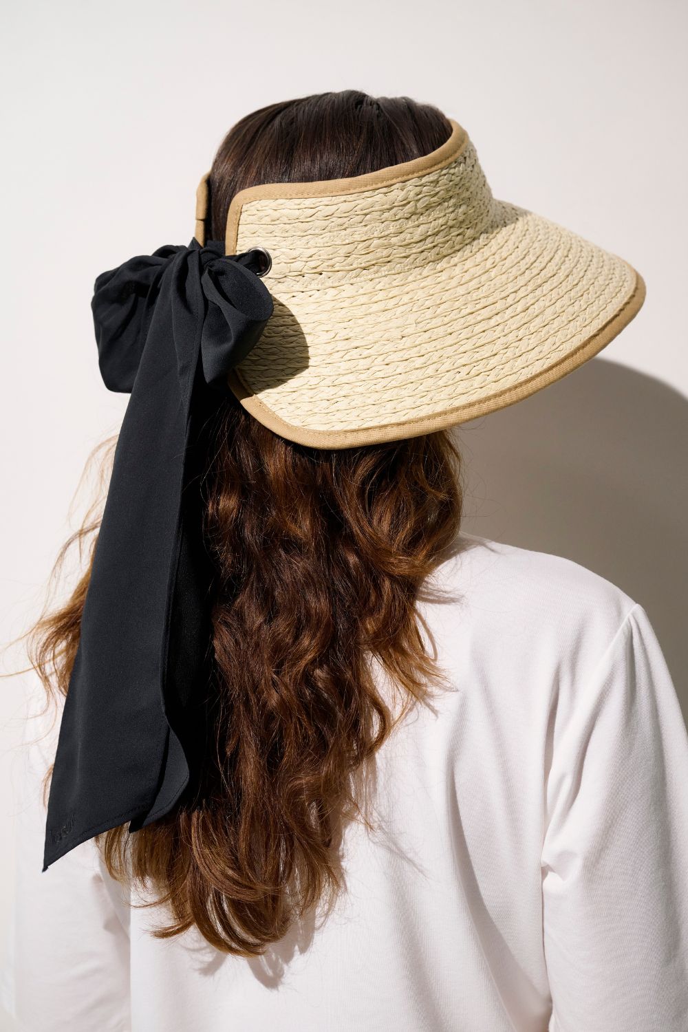 Visière anti-UV - Rimini beige avec ruban noir, parfaite pour protéger le visage au soleil, élégante et confortable.