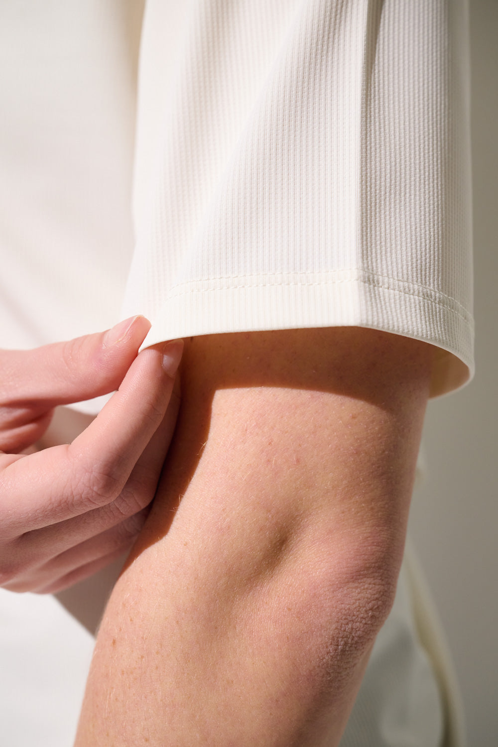 Détail d'un t-shirt anti-UV - Boston pour femme, tissu léger et respirant avec manches légèrement retroussées.