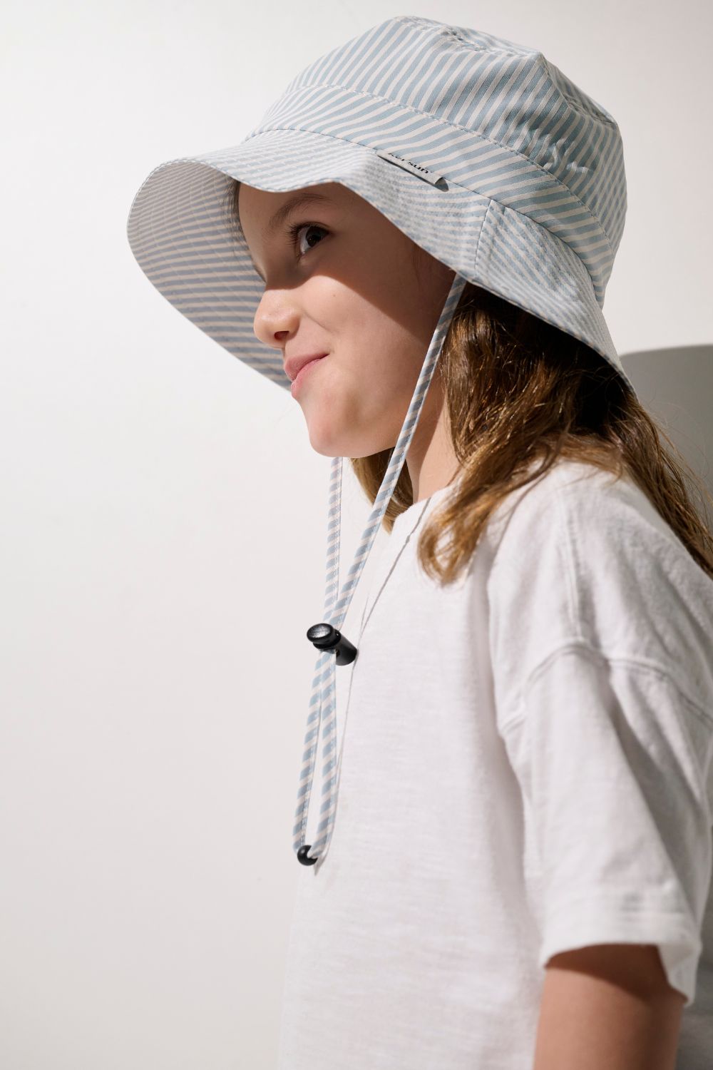 Bob anti-UV - Sylt à rayures, porté par un garçon, idéal pour une protection solaire avec UPF 50+.