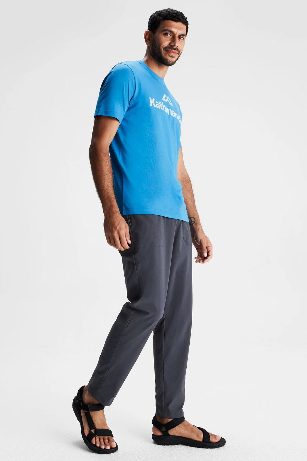 Homme portant un pantalon anti-UV Miro gris et un t-shirt bleu, idéal pour la ville et les sentiers, UPF 50+.