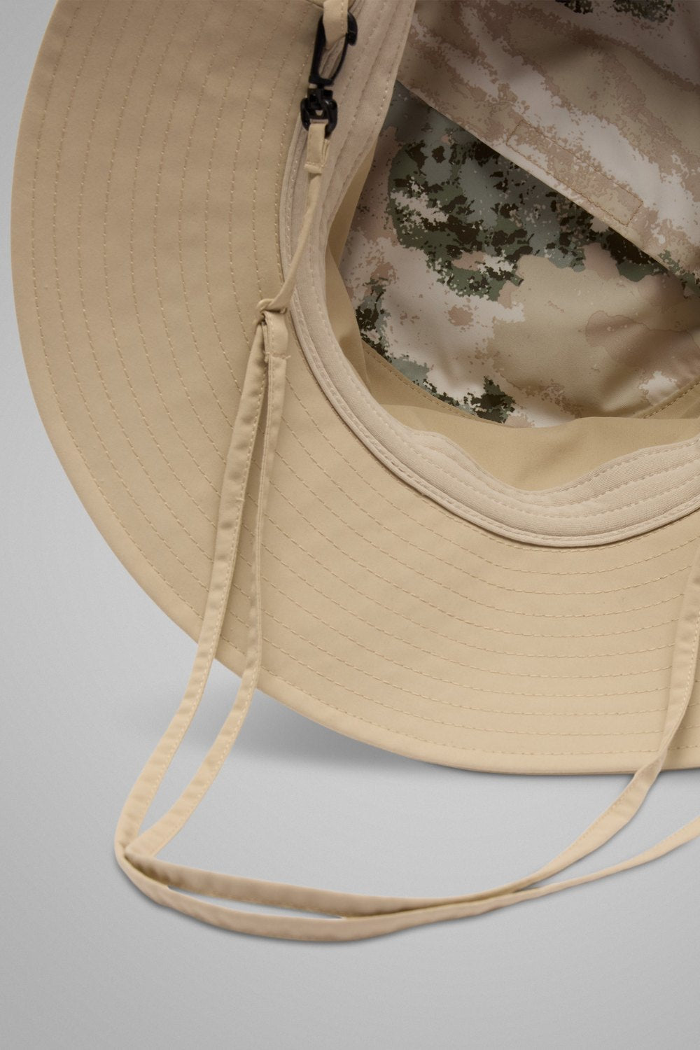 Bob anti-UV packable beige avec lanière, offrant protection solaire UPF 50+ pour les activités en extérieur.