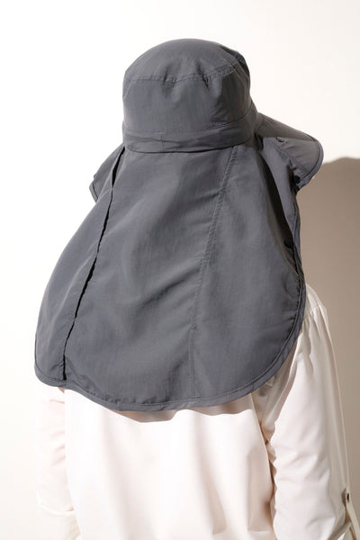 Chapeau anti-UV gris modulable pour femme, offrant une protection solaire UPF50+ lors d'activités en plein air.