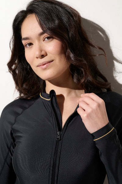 Maillot de bain anti-UV noir pour femme, avec liseré doré, certifié UPF50+ pour protection solaire optimale.