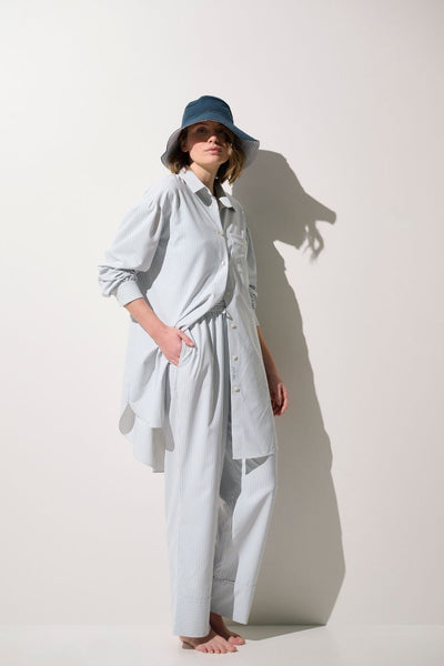 Chemise longue anti-UV - Sylt, légère et élégante, portée par une femme avec un chapeau, pour protection solaire.
