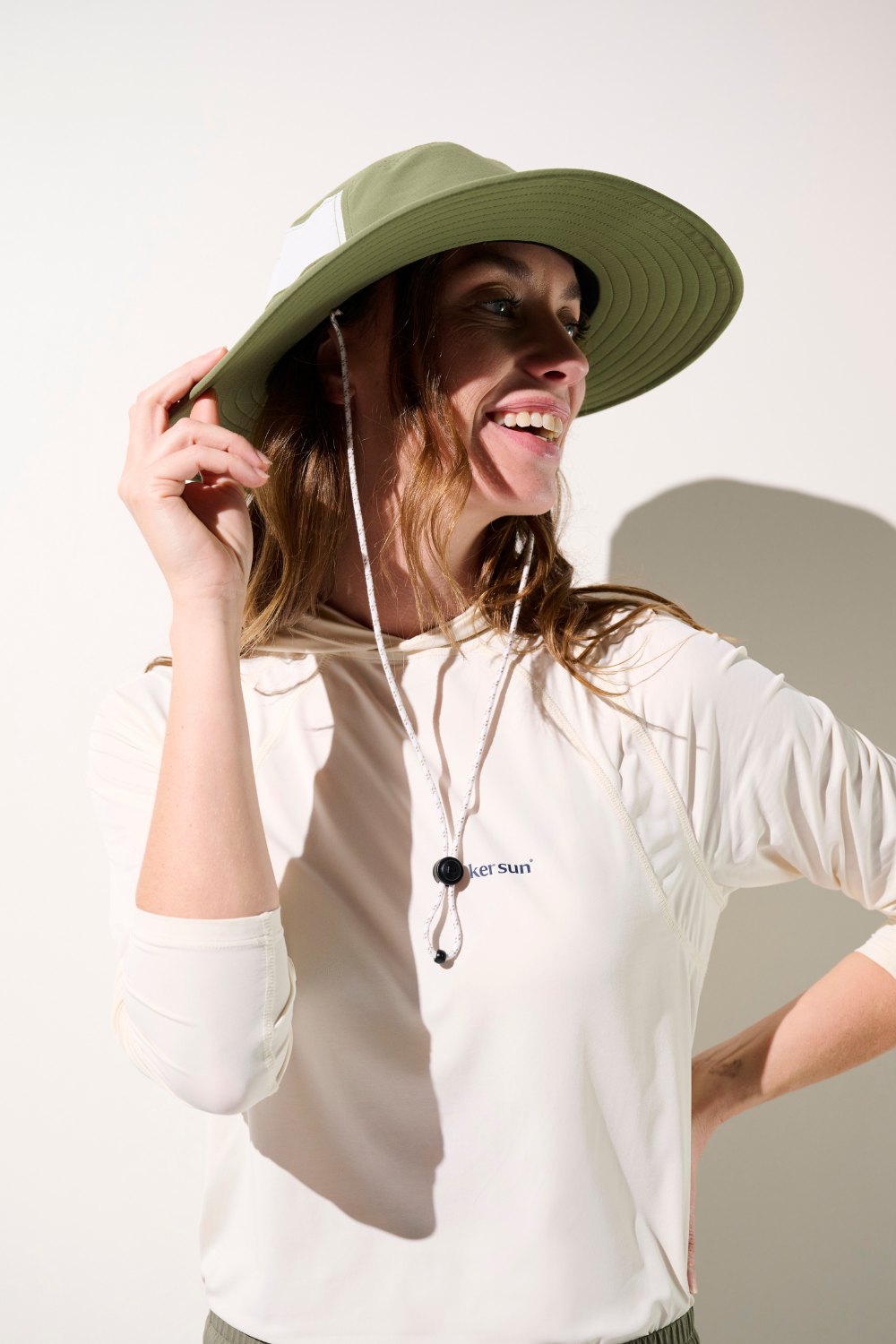 Femme souriante portant un chapeau anti-UV - Oasis, léger et UPF 50+, idéal pour les activités en extérieur.